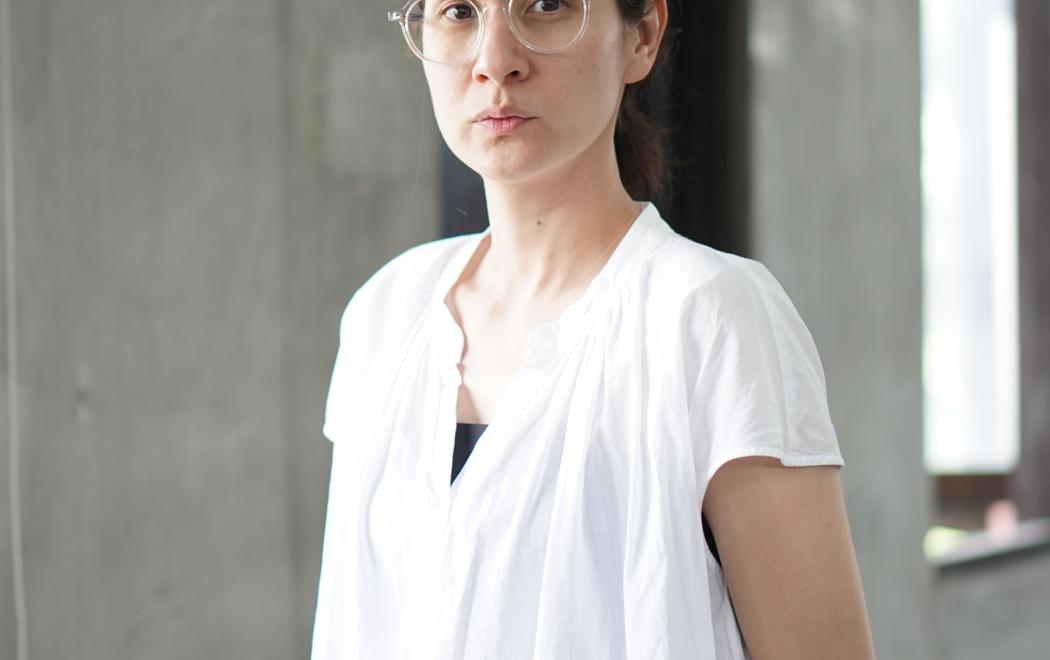 A woman in a white shirt and glasses