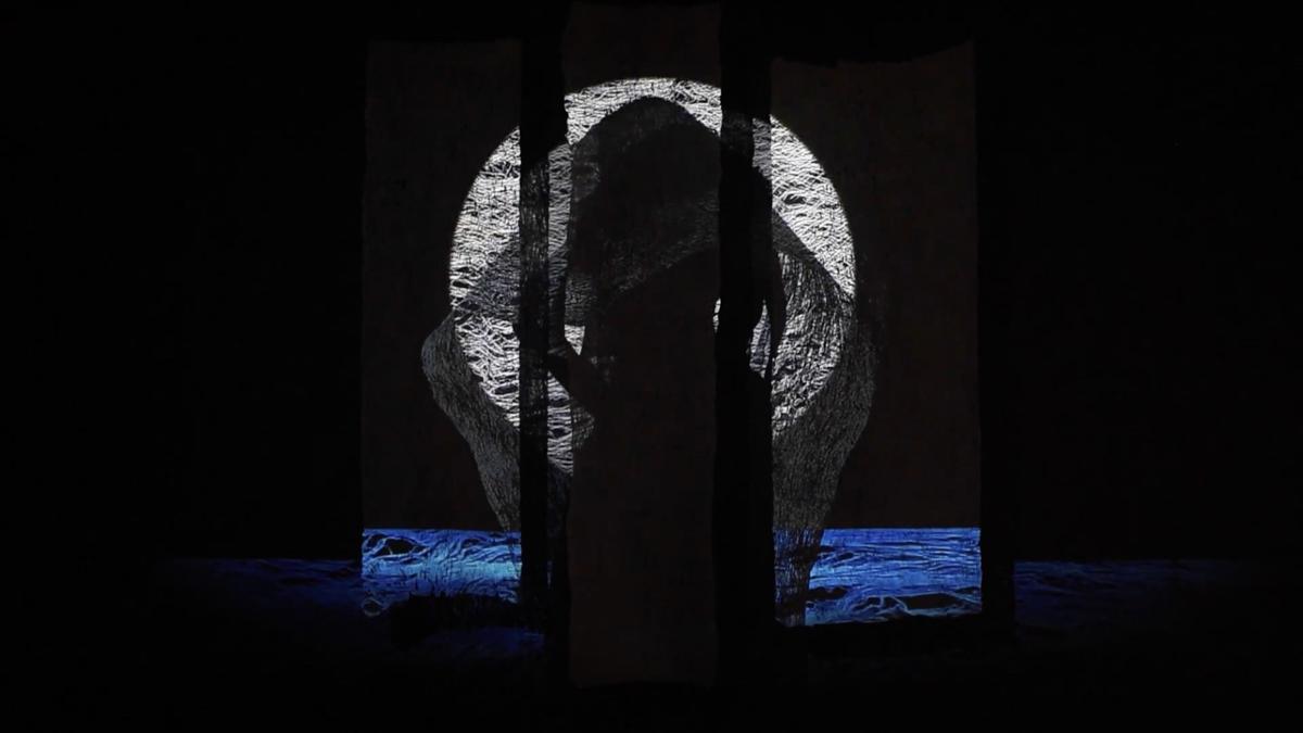 A white circular form is projected across three panels of barkcloth, while a blue band resembling water extends along the bottom edge of the projection. The silhouette of a figure draped in tapa lies at the centre.